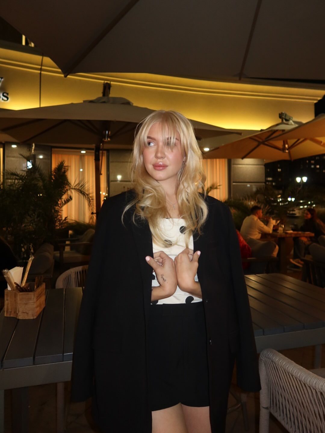 Veronika Mochalova in black blazer on evening restaurant terrace