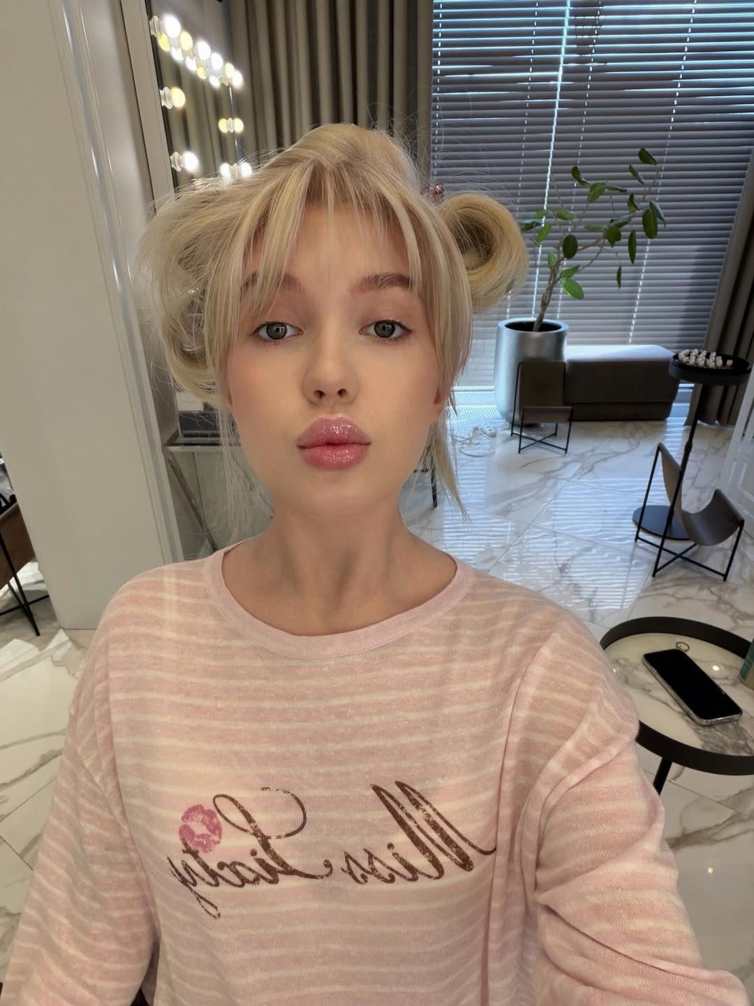 Veronika Mochalova in pink sweater with double bun hairstyle
